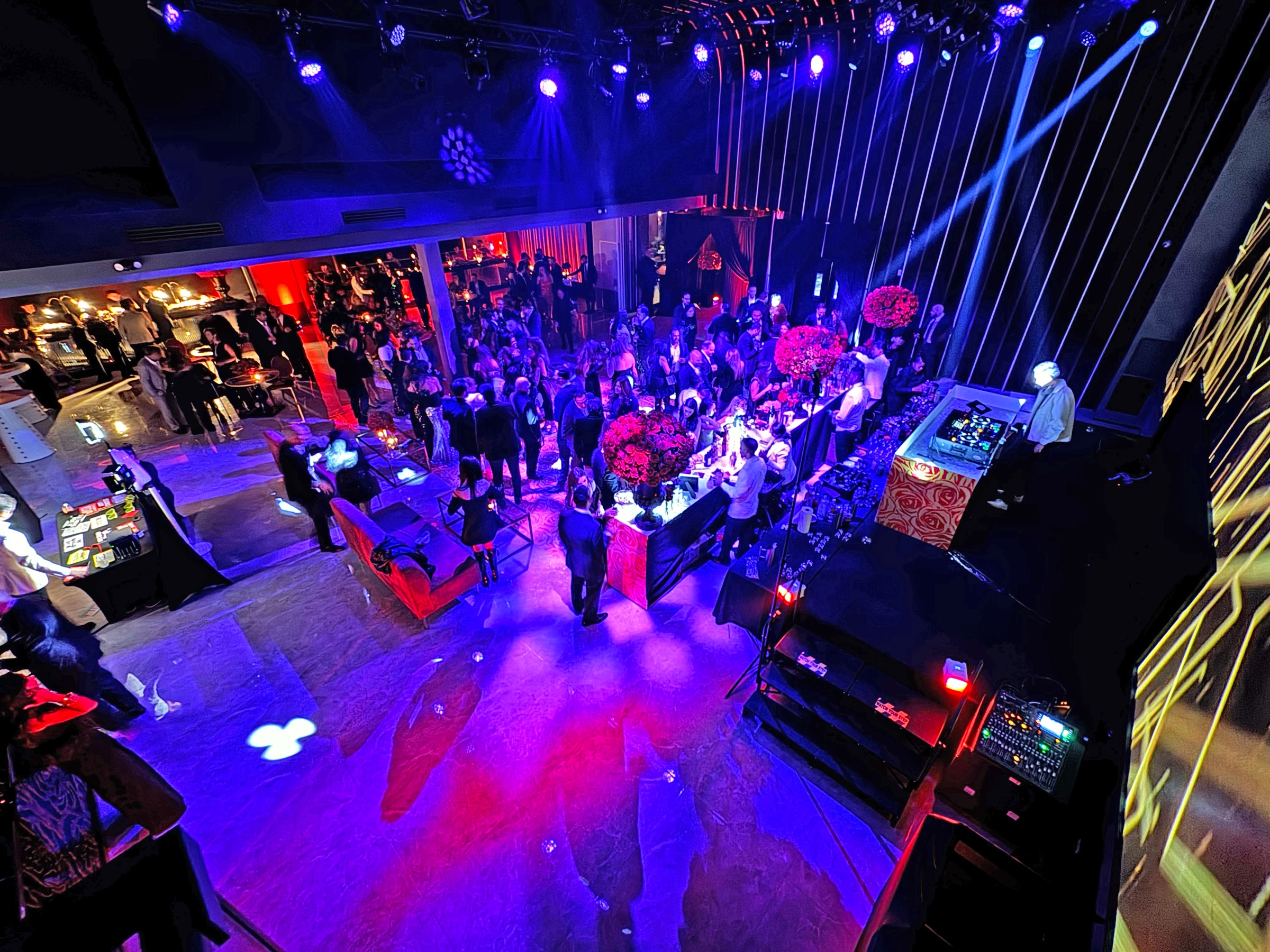 Guests gathering in the Lounge X event hall beneath colorful production lighting